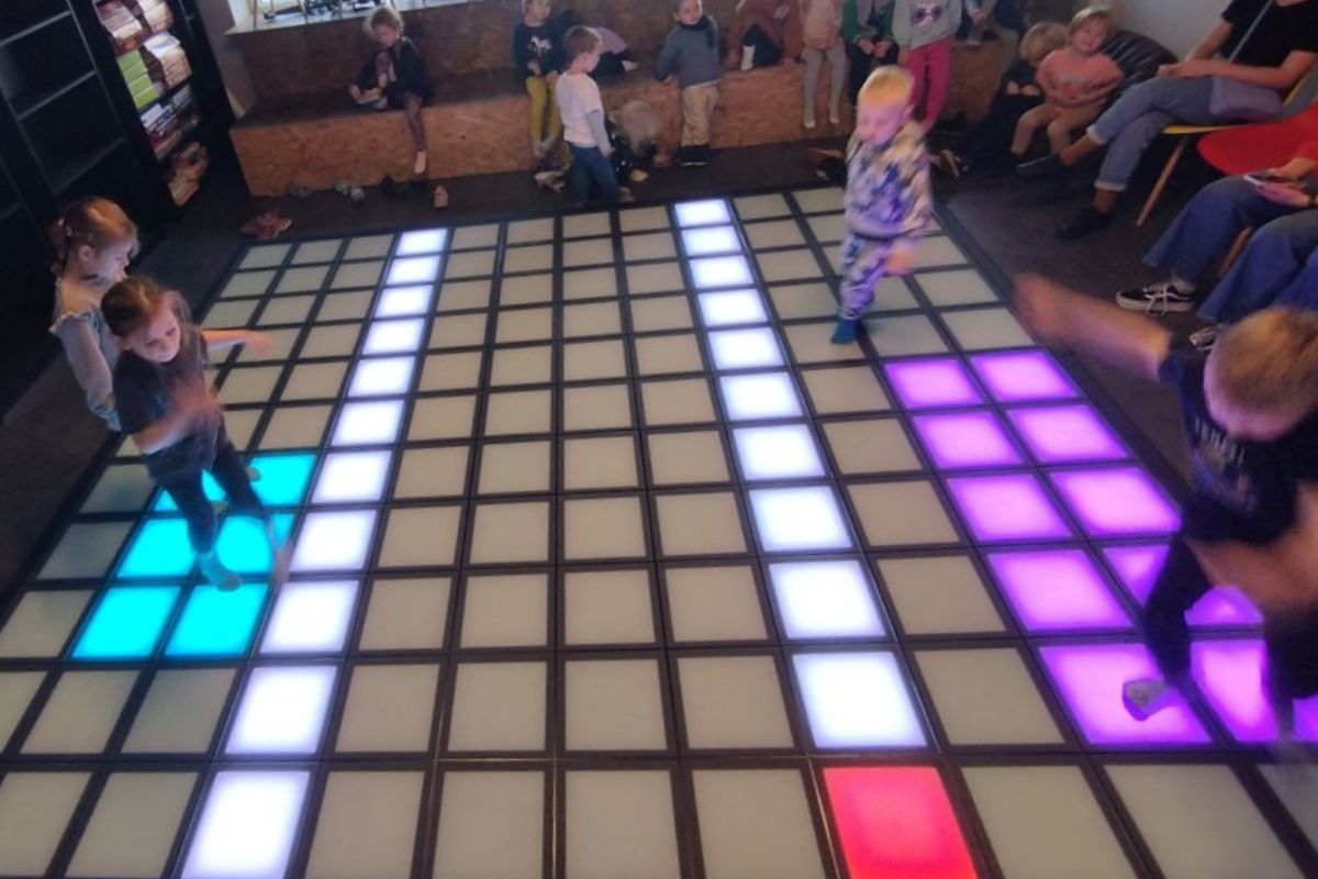 Ruchowa zabawa z pikselami – dzieci skaczą po matce LED